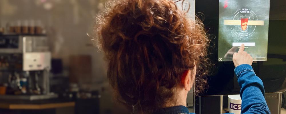 woman using touchscreen coffeemaker